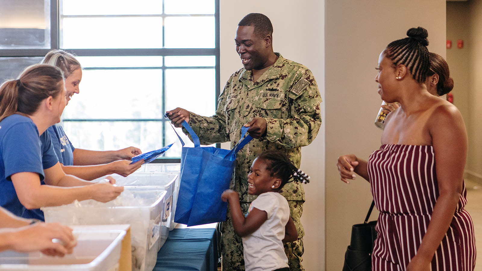 Service Member helps daughter pick out school supplies at a Back-to-School Brigade