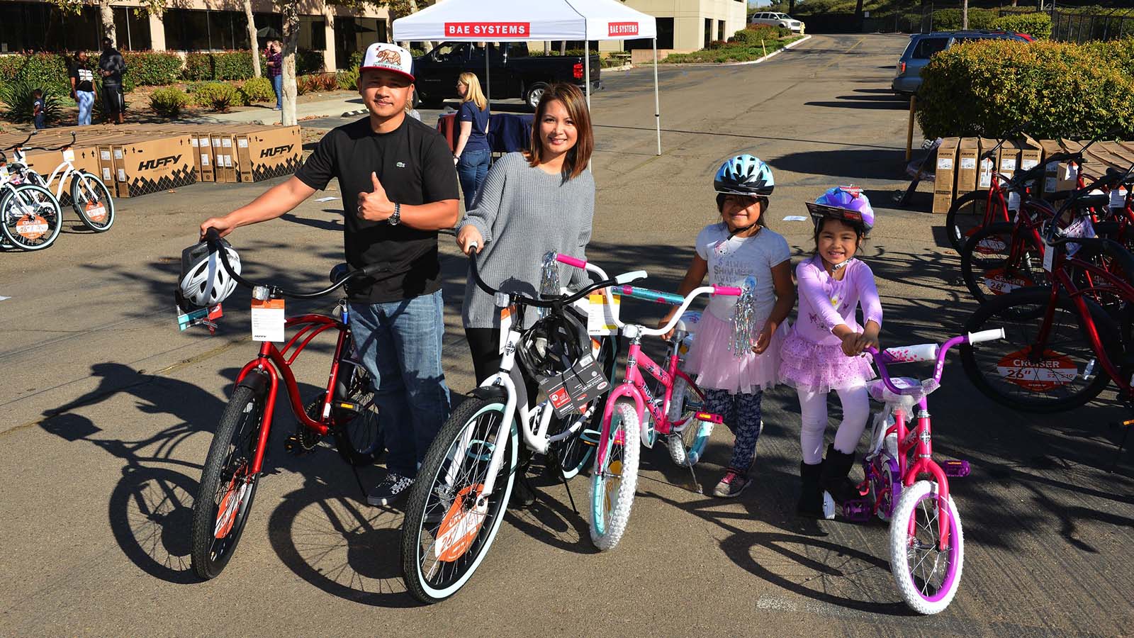 Mom and Dad standing side by side with their kids and their new bikes that they received at an Operation Homefront event.