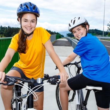 Teenagers riding bikes outside.