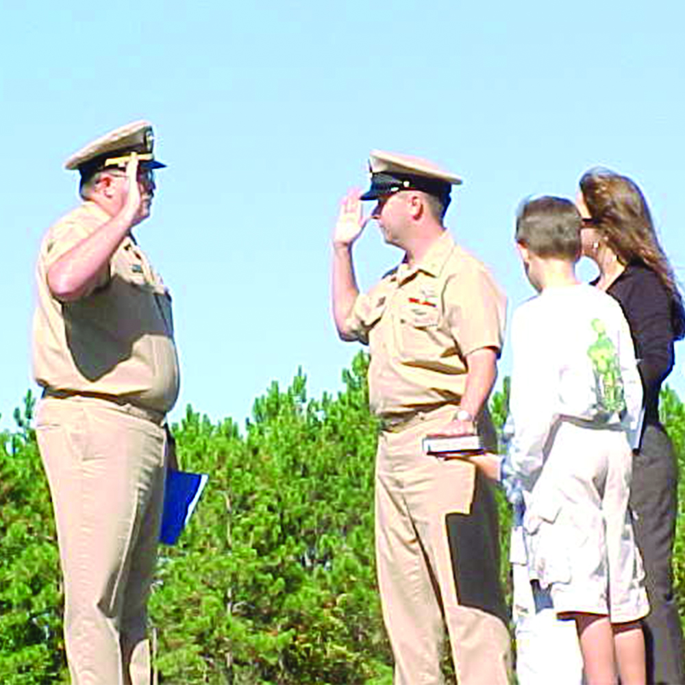 Saluting military personnel with their family present.