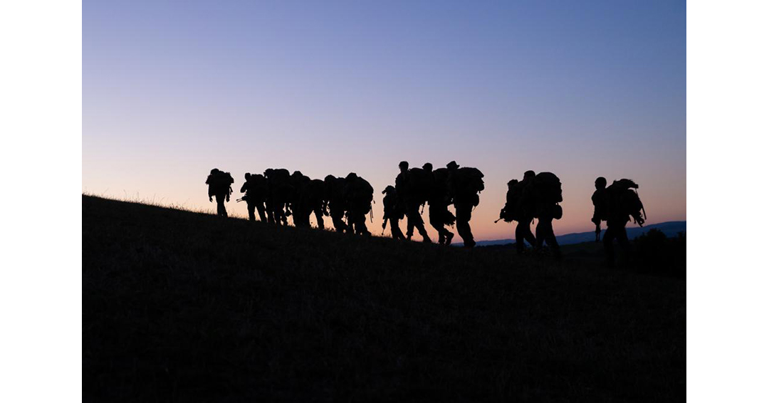 Soldiers marching at sunset.