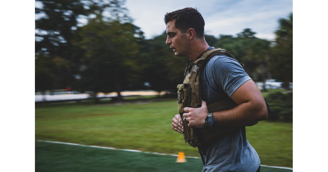 Military soldier running with weight vest.