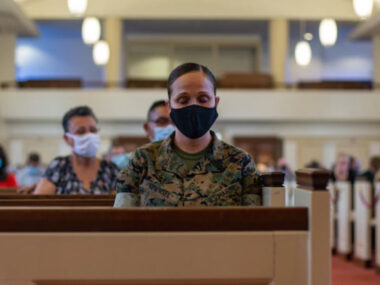 Female marine soldier sitting in church.