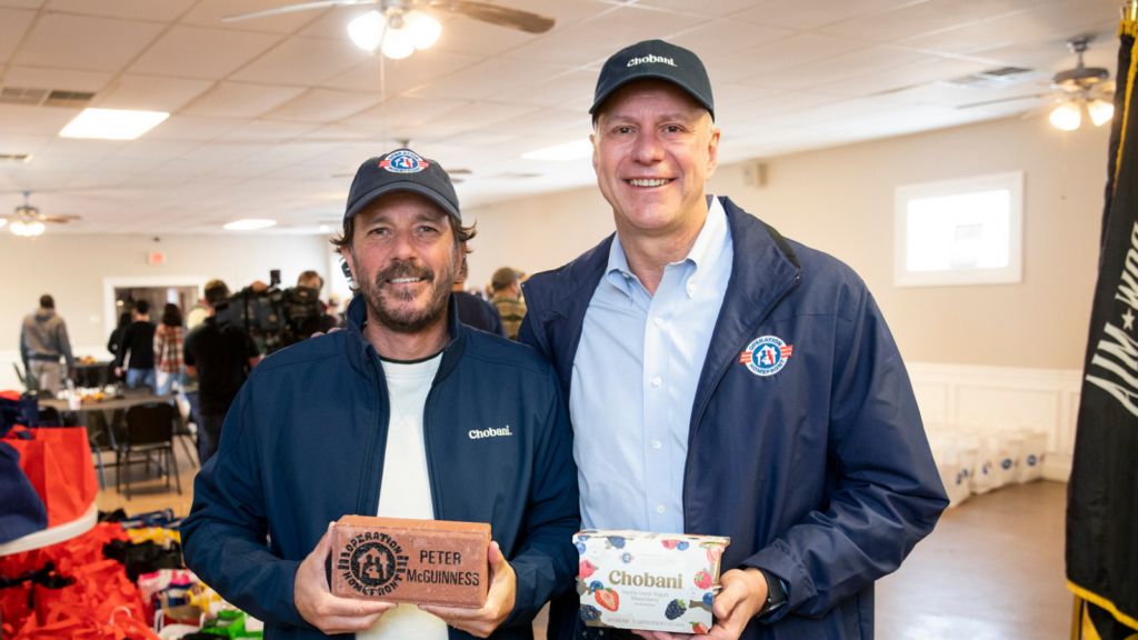 Two people smiling at an event.