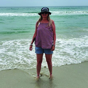 Woman standing in water on the beach.