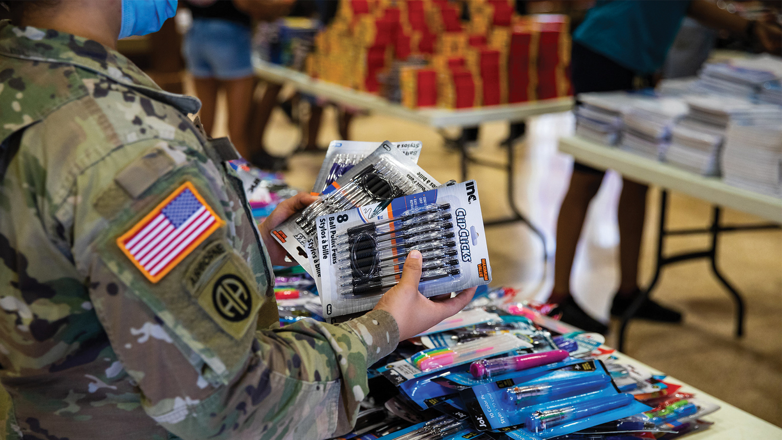 Service member distributing back to school free supplies.