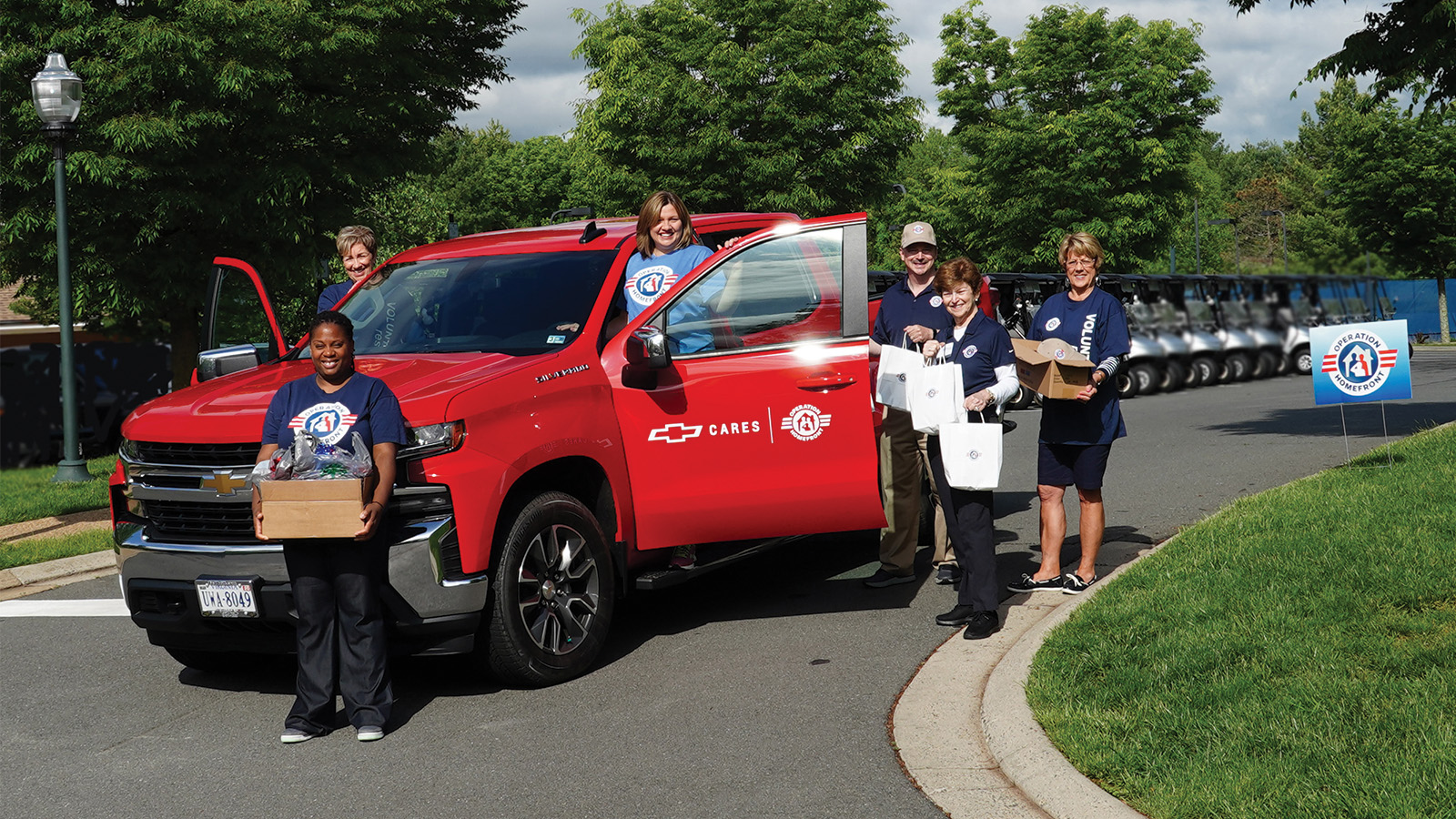Operation Homefront volunteers pictured outside a a red chevy truck.