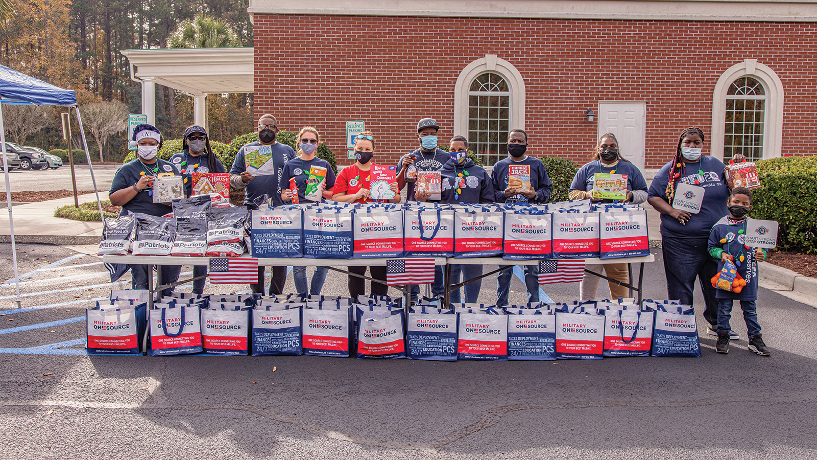 Group of volunteers with holiday meal gift bags.