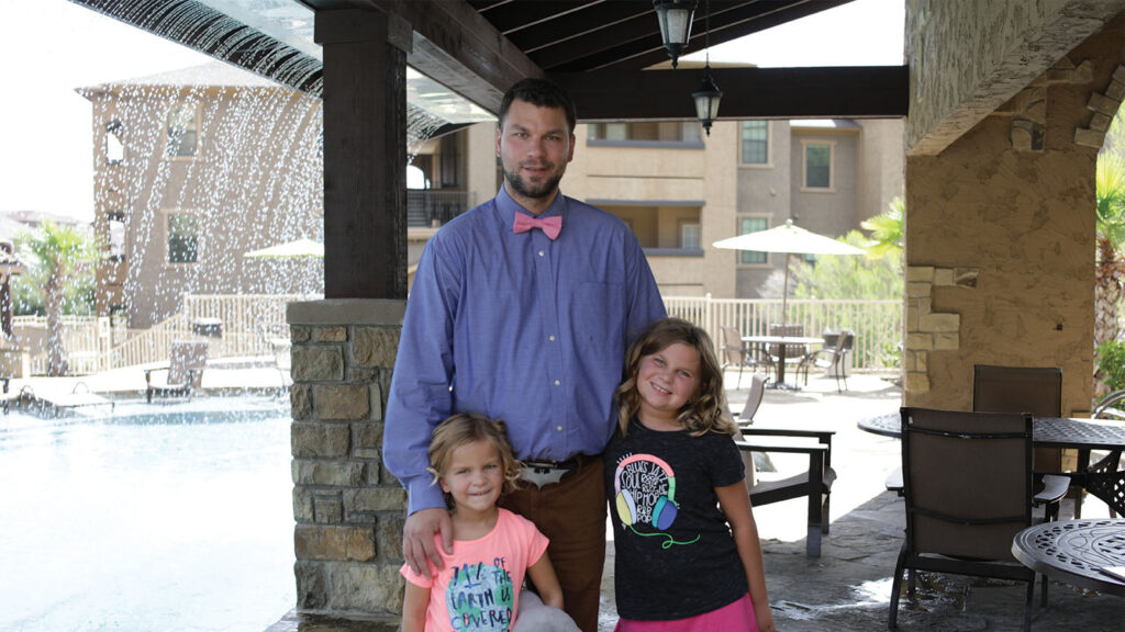 Photo of a family standing in a veteran housing village.