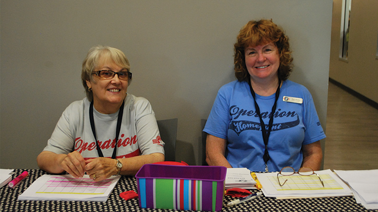 Volunteers at an event table to serve military families,