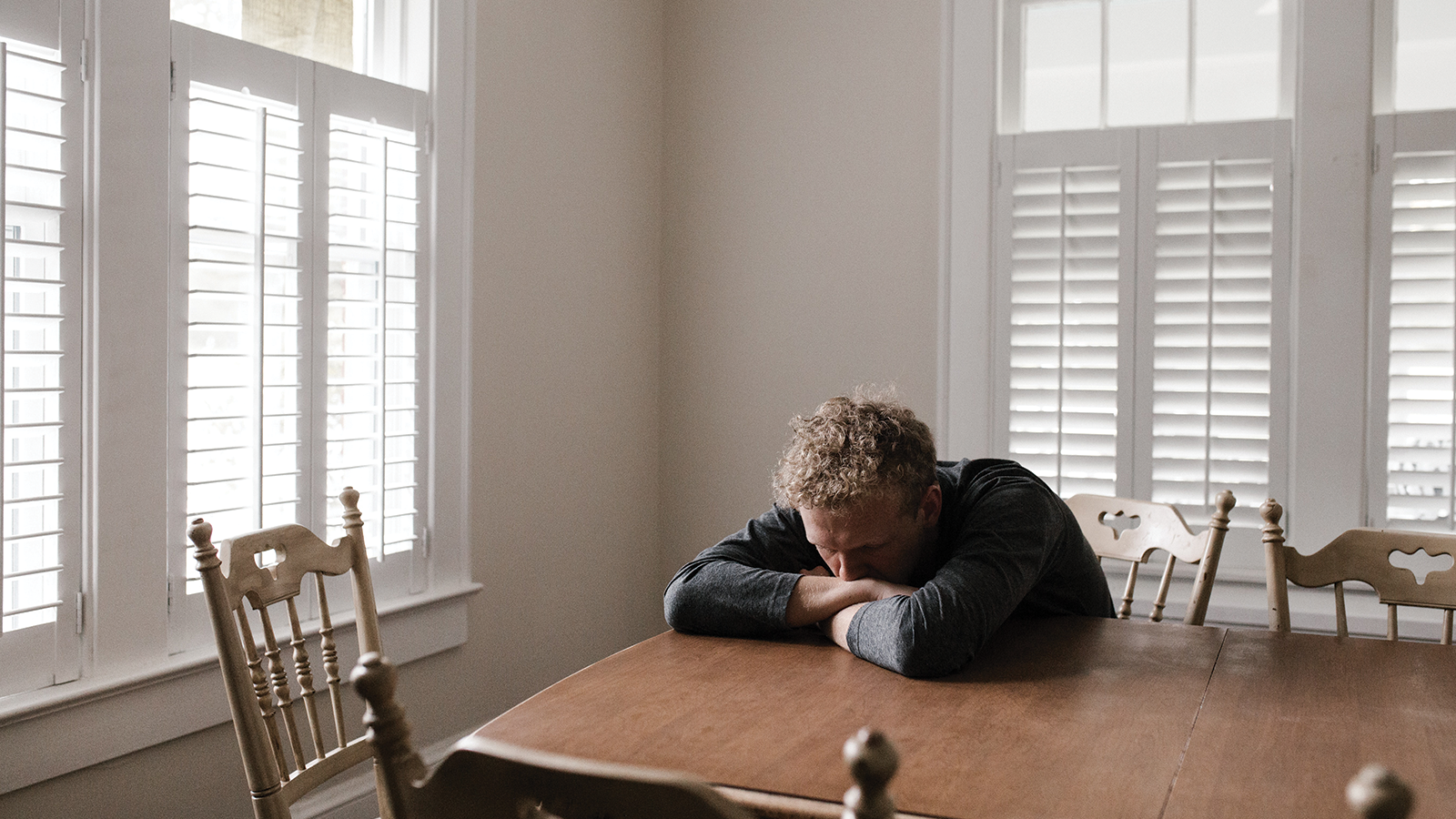 man at table with head down