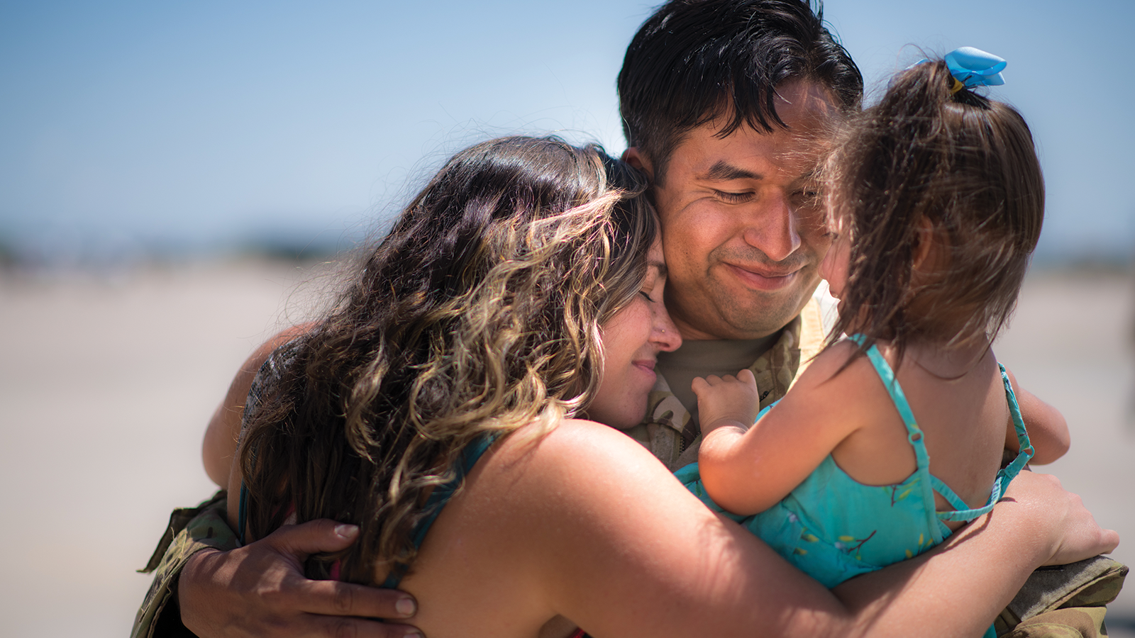 military person hugging family