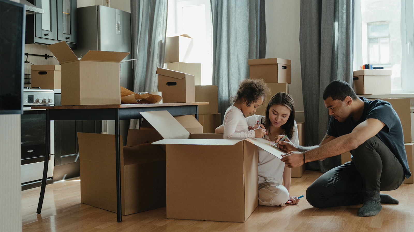 family surrounded by many moving boxes