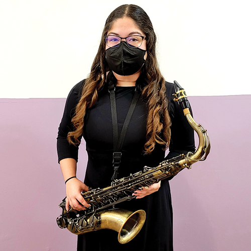 Masked person holding a saxophone