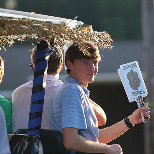 boy on back of golf cart