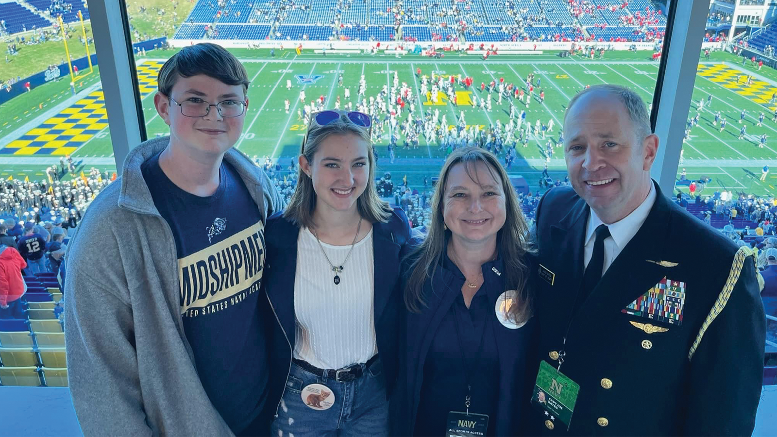 Military amily standing in the press box at a football game
