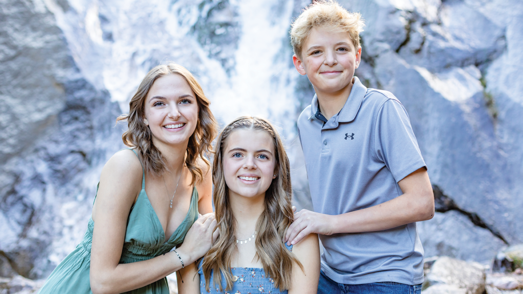 Two sisters and a brother smiling