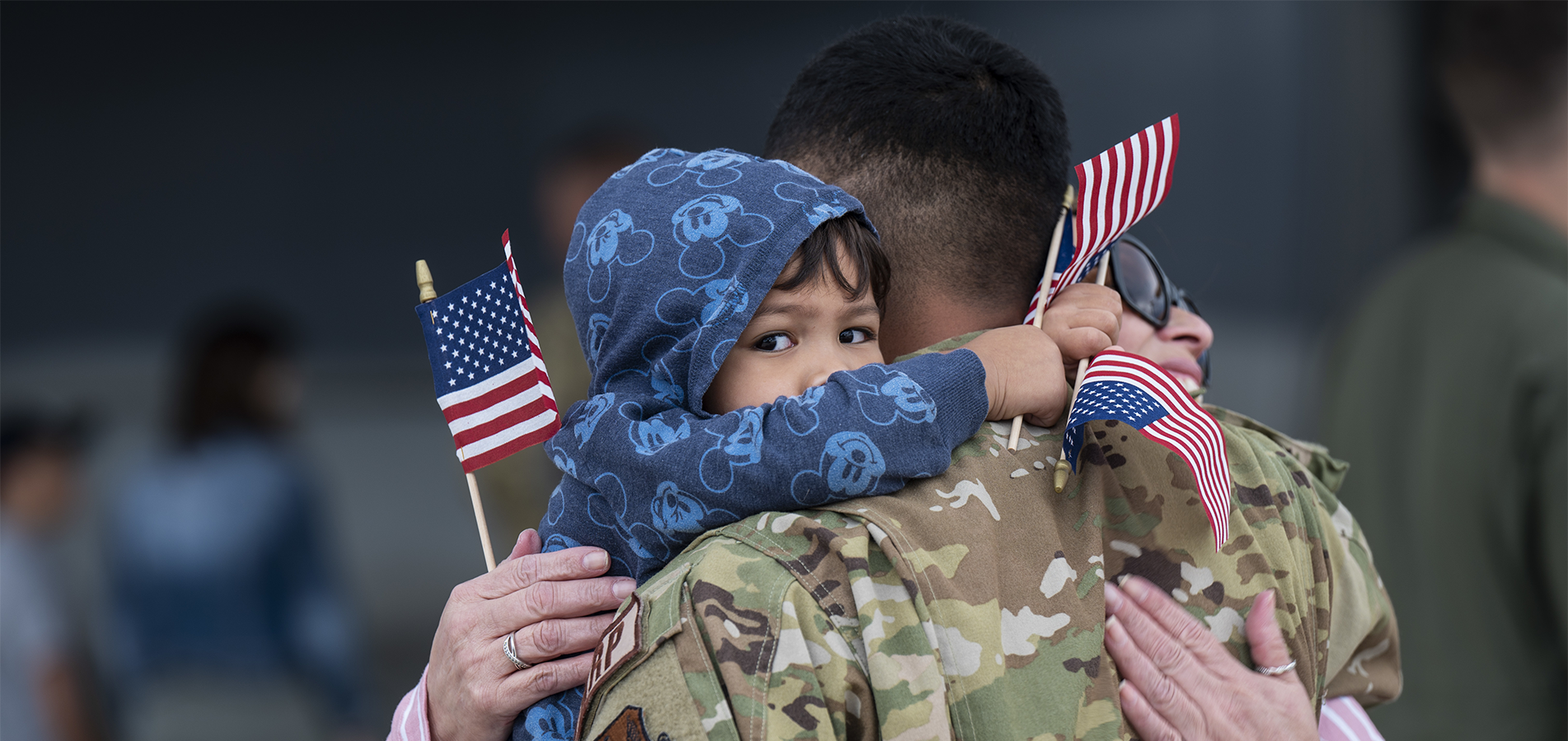Little boy hugging his father who is in military fatigues