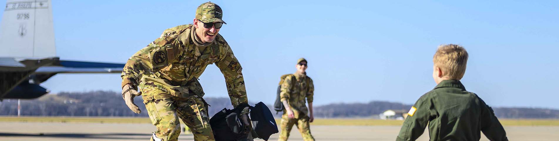 Small boy running to hug his Airman Dad