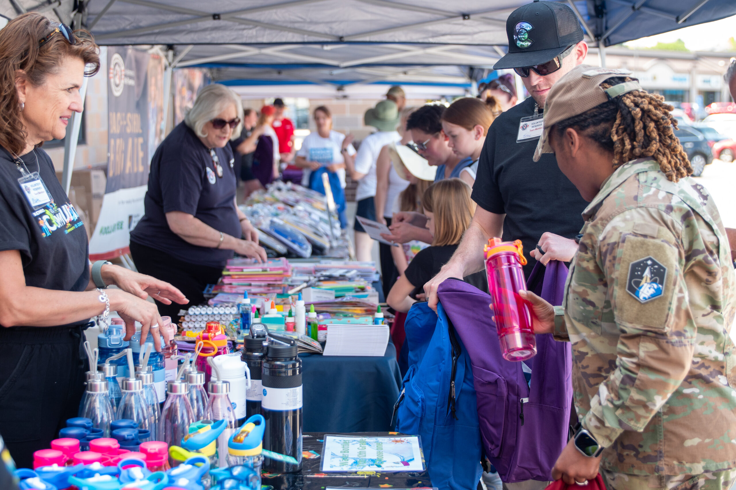 volunteers helping military families fill their children's backpacks