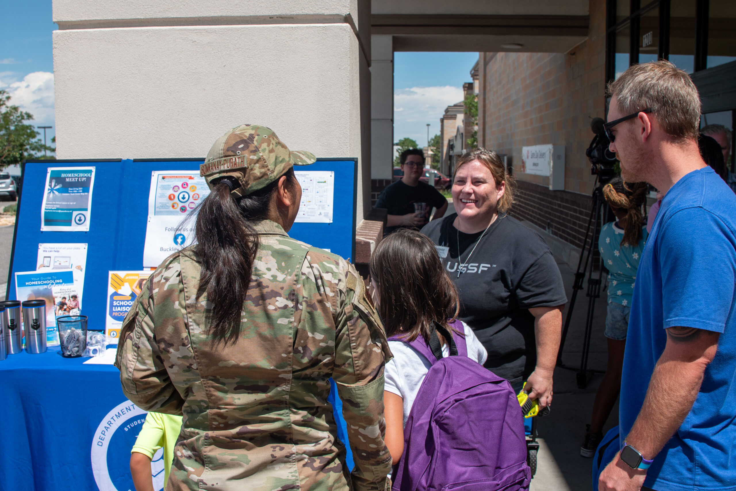 mom and daughter with her backpack talking to an operation homefront volunteer