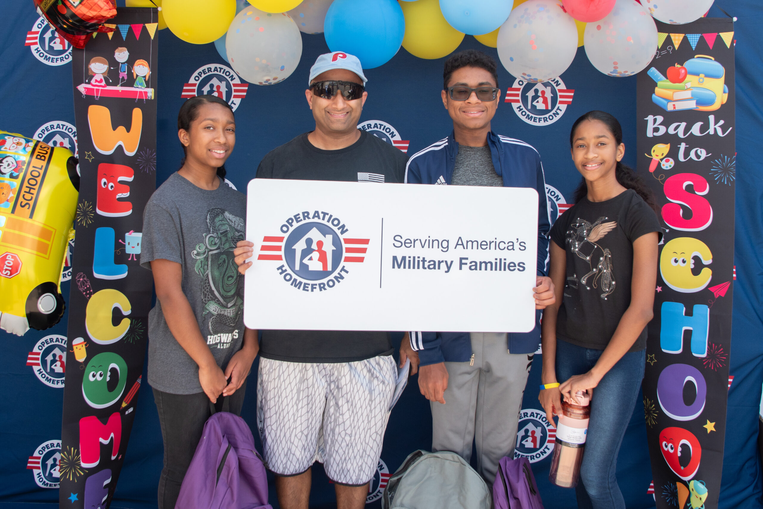 father, son, and two daughters holding an operation homefront sign