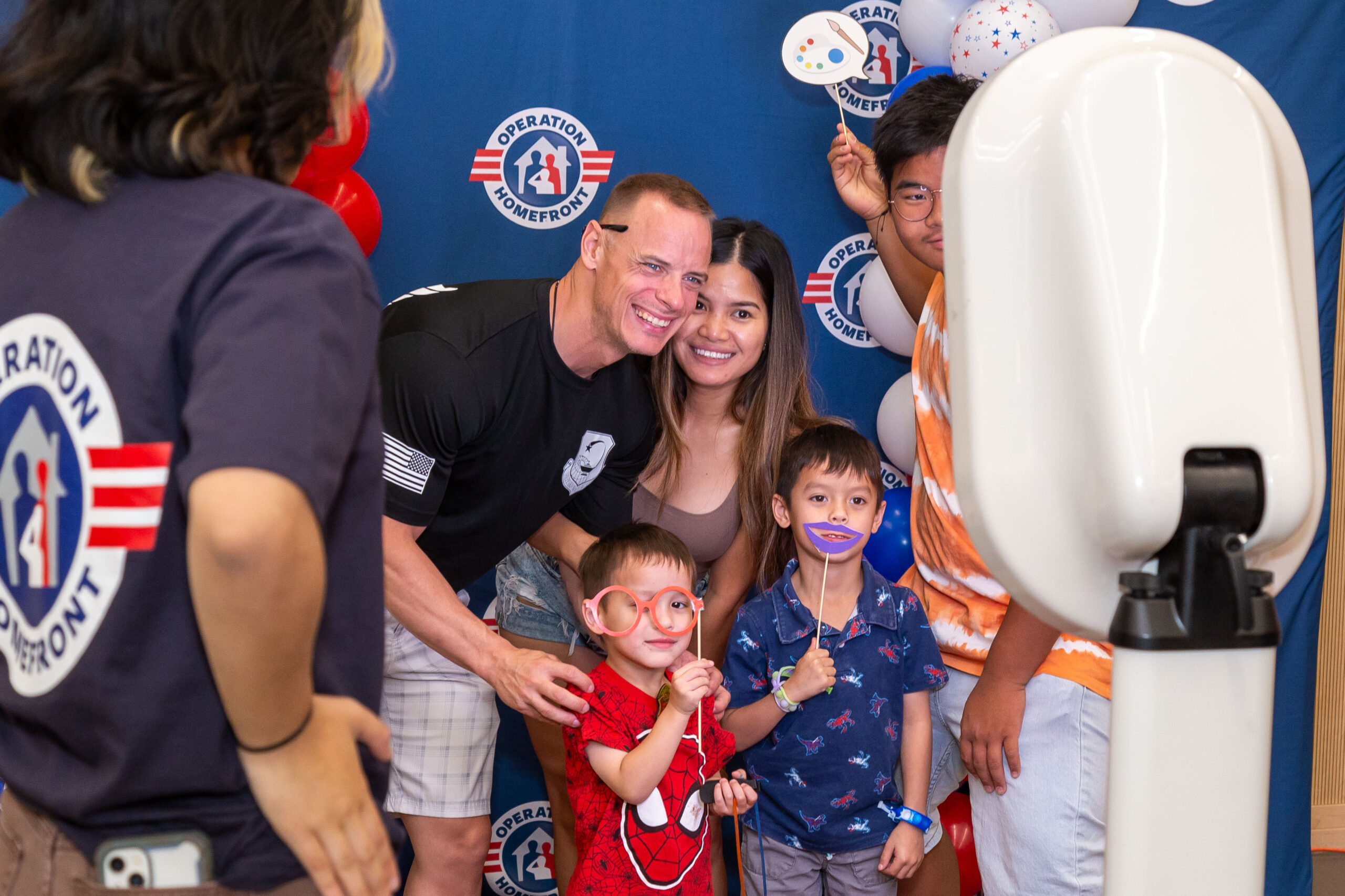 mom, dad, and children taking a photo with props