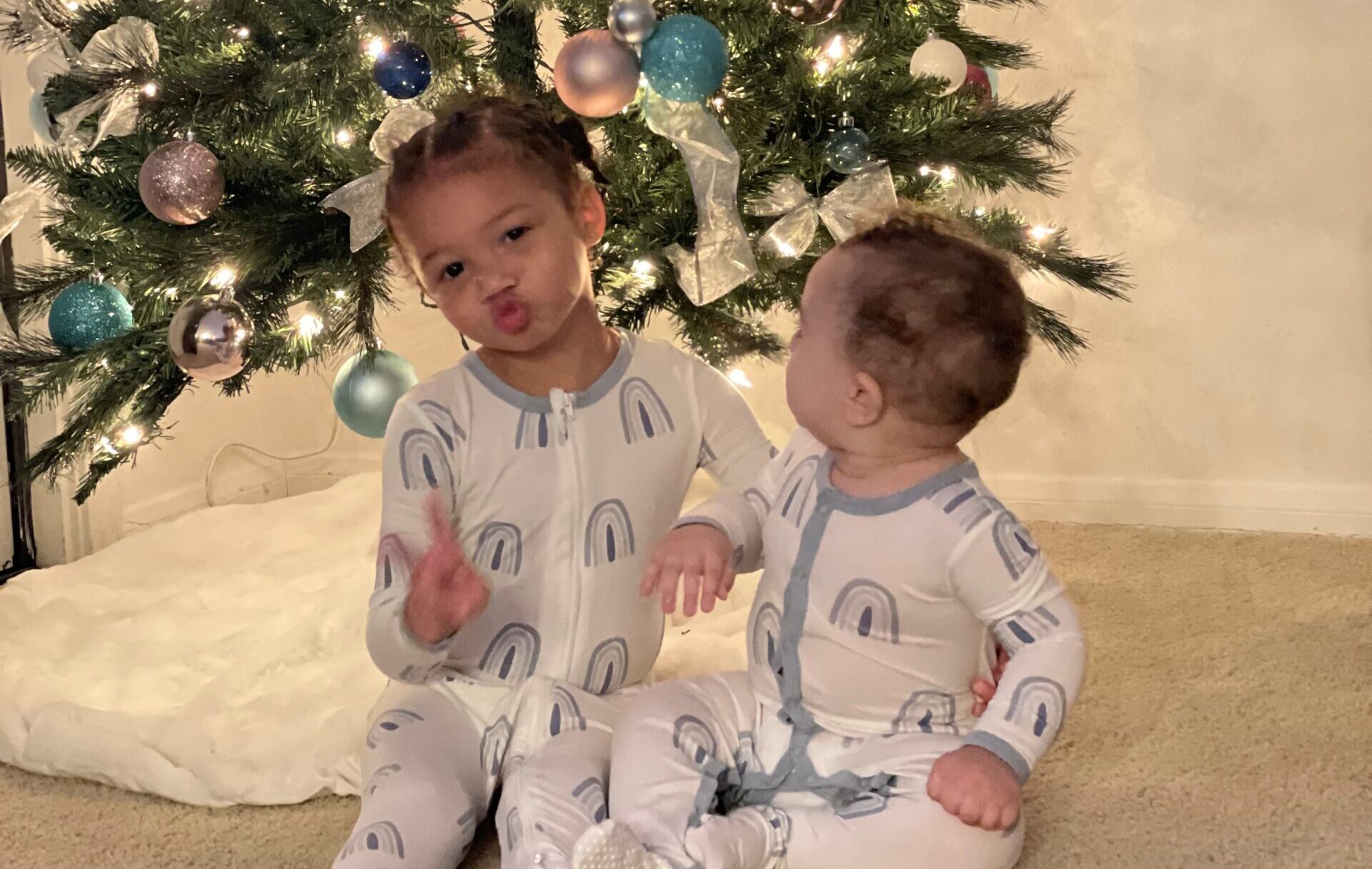 two kids in front of a christmas tree