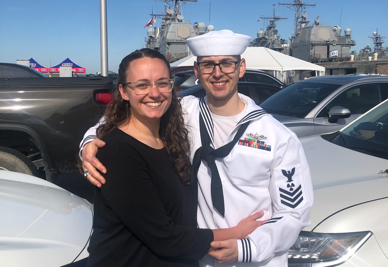 man in uniform hugging his civilian wife