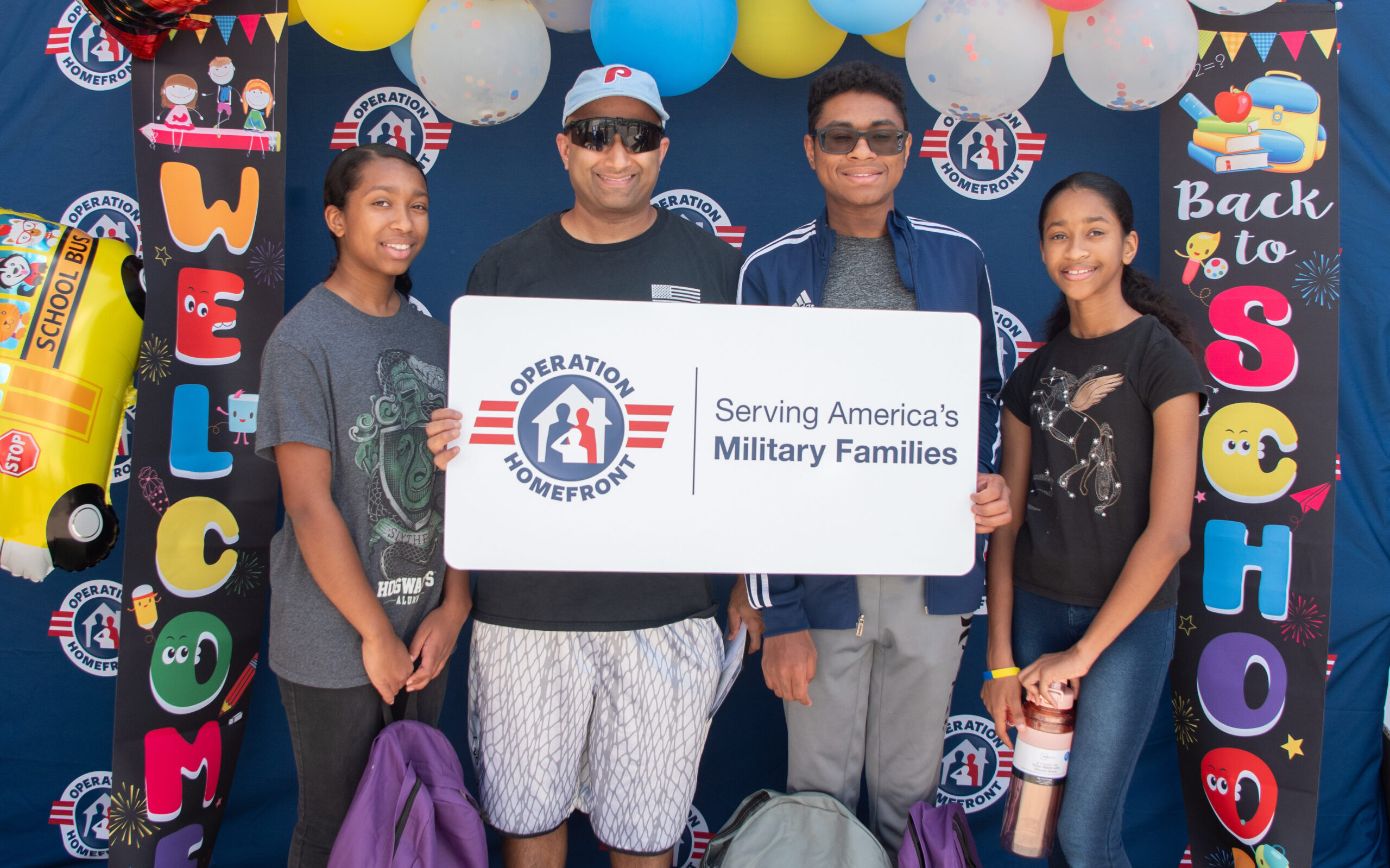 father, son, and two daughters holding an operation homefront sign