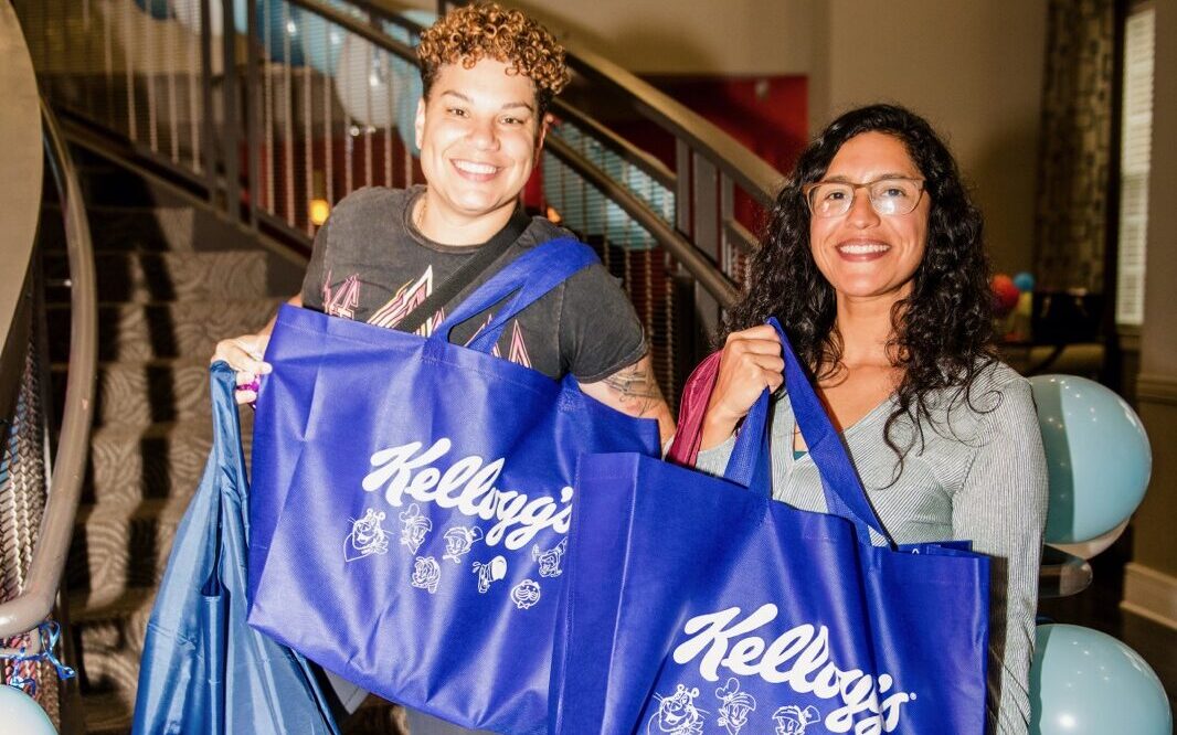 two woman holding kelloggs swag bags